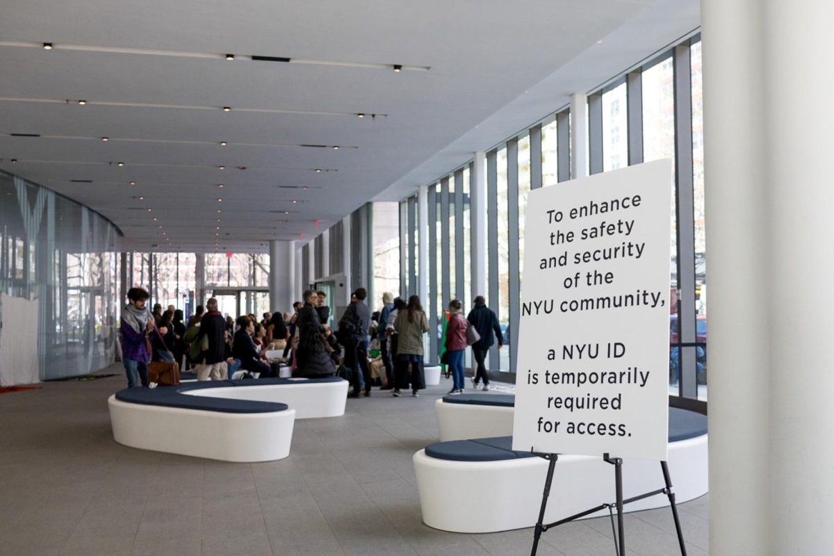 Paulson Center lobby focusing on a white sign that says “TO ENHANCE THE SAFETY AND SECURITY OF THE N.Y.U. COMMUNITY, A N.Y.U. I.D. IS TEMPORARILY REQUIRED FOR ACCESS.”