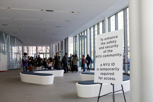 Paulson Center lobby focusing on a white sign that says “TO ENHANCE THE SAFETY AND SECURITY OF THE N.Y.U. COMMUNITY, A N.Y.U. I.D. IS TEMPORARILY REQUIRED FOR ACCESS.”