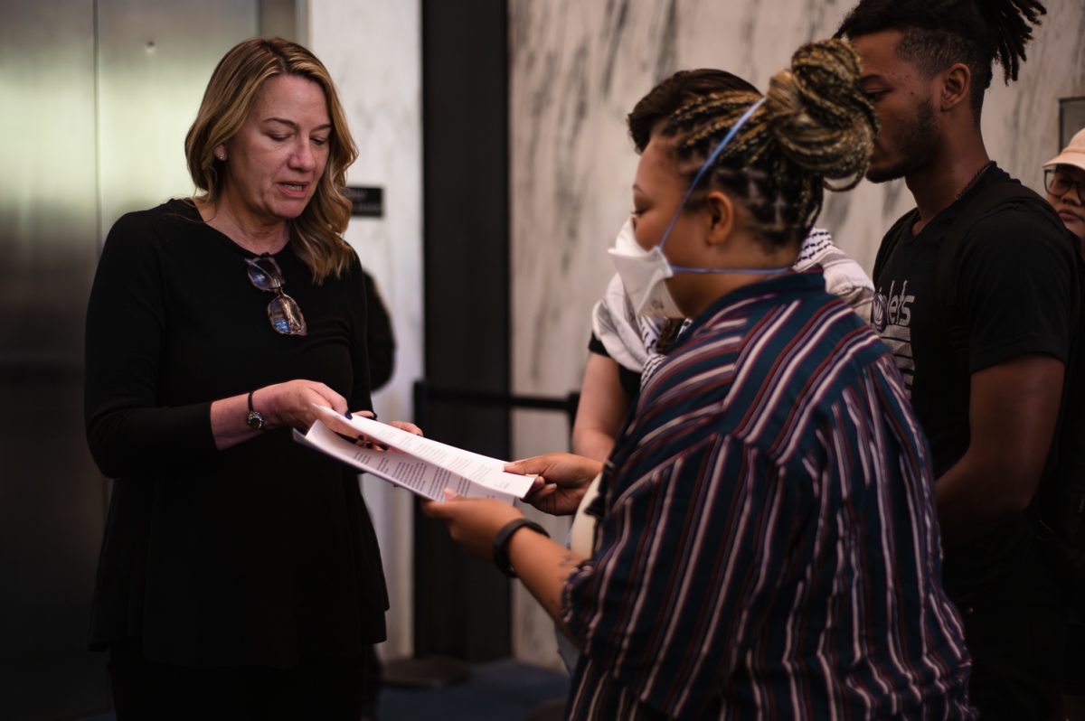 A woman handing a letter to another woman.