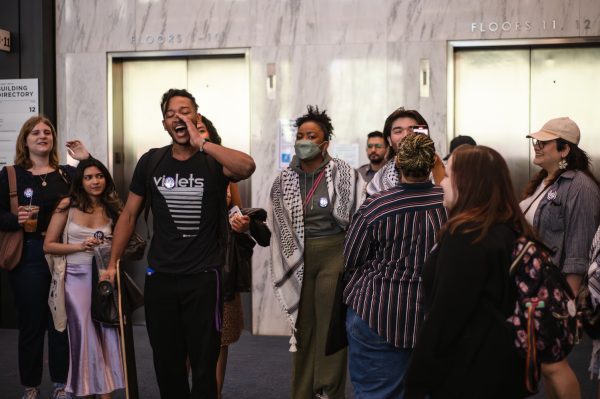 A group of people chanting and cheering in a lobby.