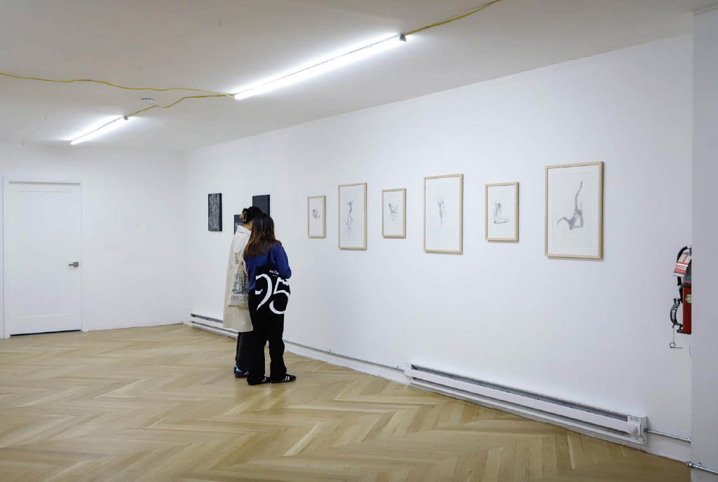 People look at paintings in an art gallery.