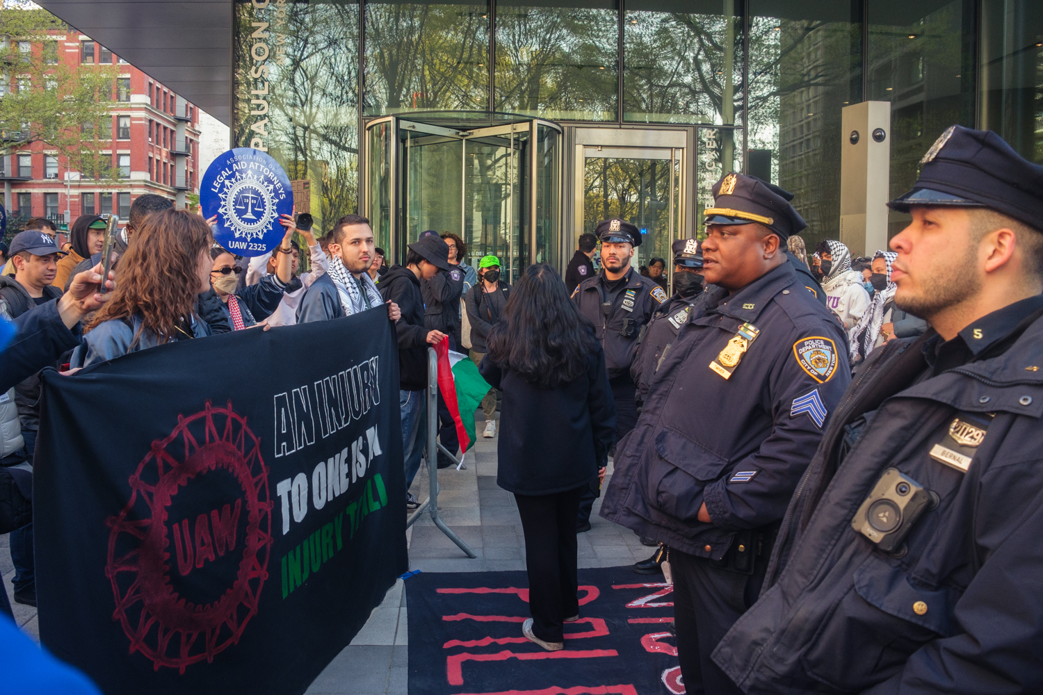 Protesters from the Graduate Student Organizing Committee stand across N.Y.P.D. officers in front of the Paulson Center.