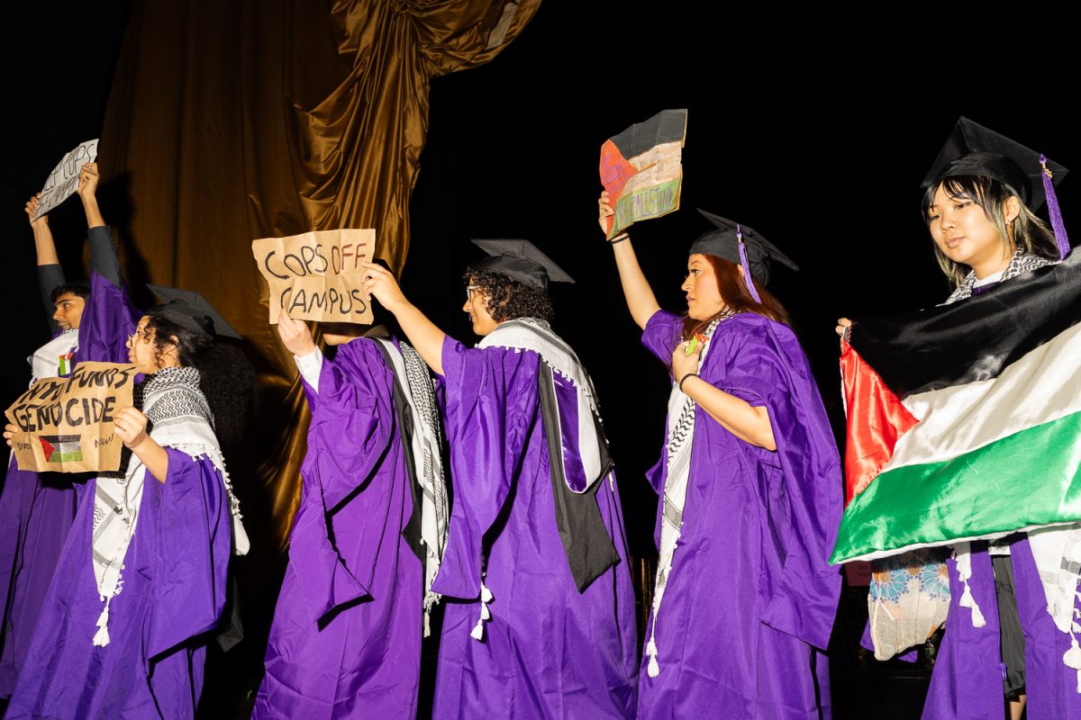 A group of graduates at the Tisch ceremony held signs and Palestinian flags on stage. (Jason Alpert-Wisnia for WSN)