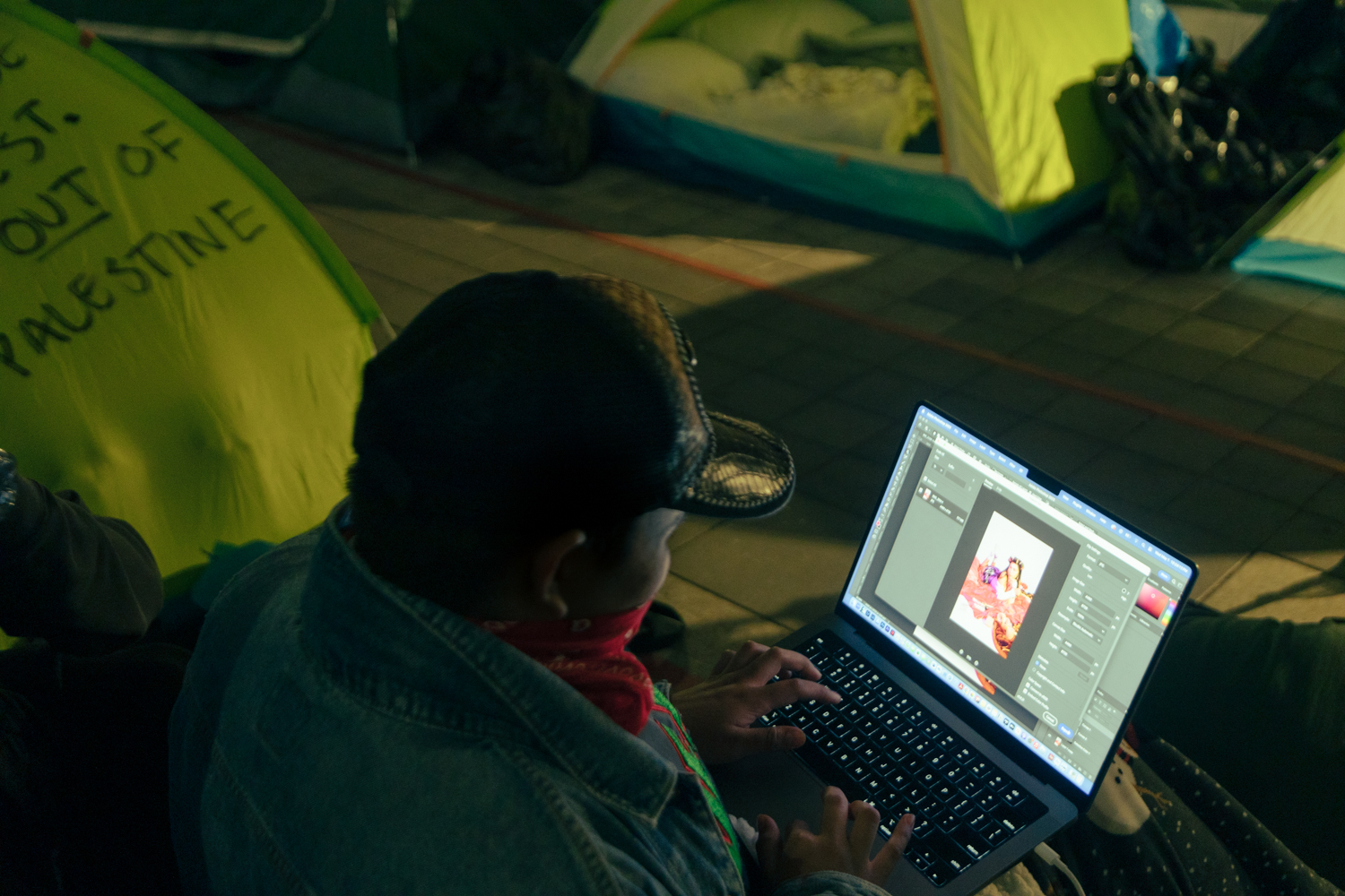 A protester edits photos inside the encampment.