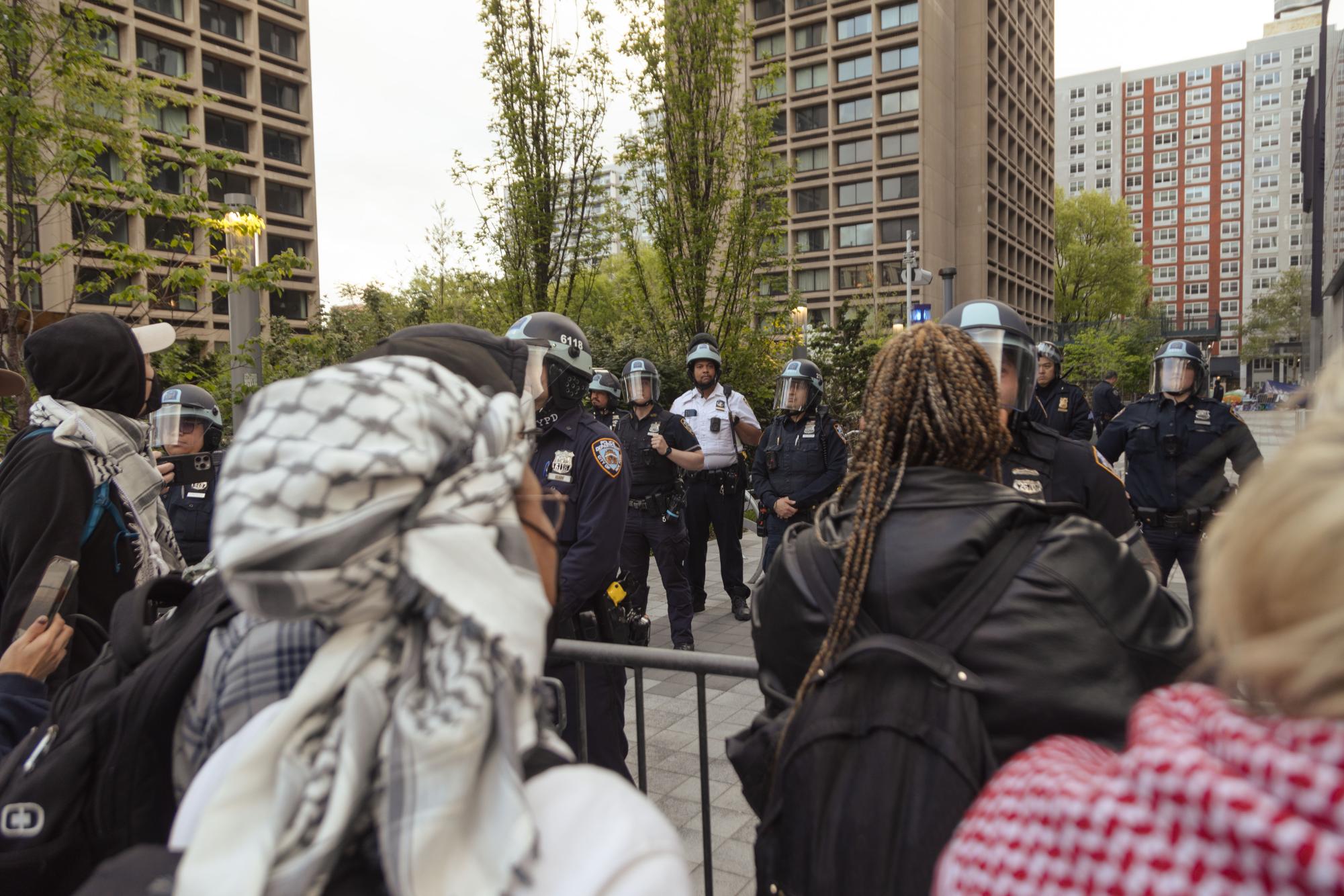 Protesters confront N.Y.P.D. officers outside the Houston Street entrance to the Greene Street Walkway.