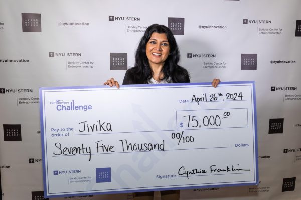 Woman holding up a large prize check for $75,000 from the Entrepreneur’s Challenge.