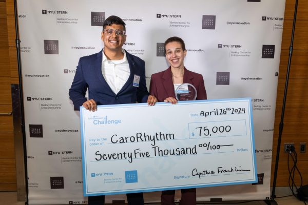 A man and woman holding up a large prize check for $75,000 from the Entrepreneur’s Challenge.
