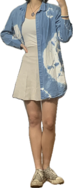 Someone wearing a white shirt, a khaki skirt, a blue and white collared shirt with gray shoes.