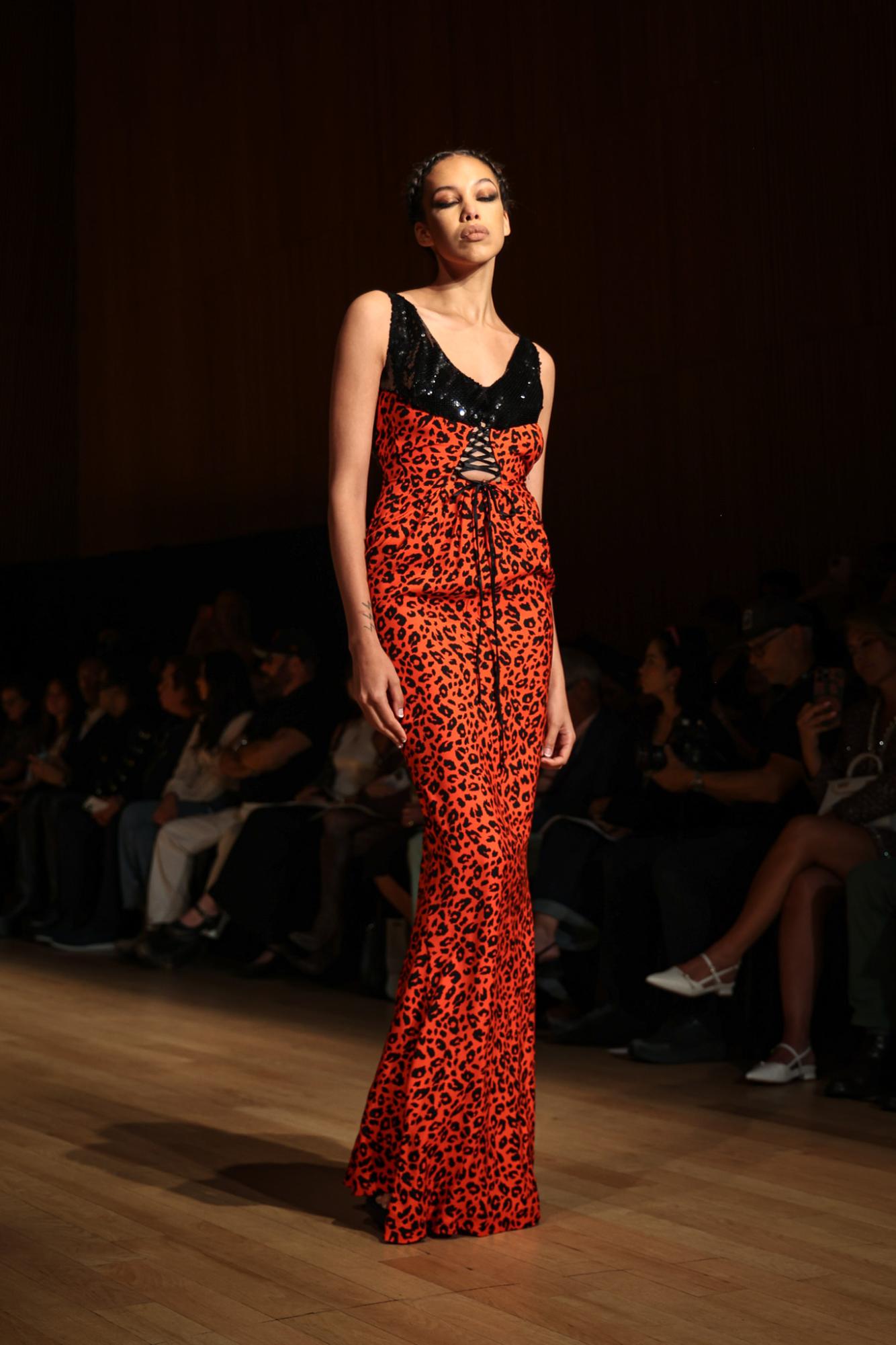 A model in a red, cheetah-print gown with a black, sequin chest piece.