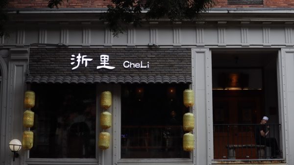 The exterior of a restaurant named "CheLi," with Chinese characters displayed above the entrance. The restaurant has a dark brick design with hanging yellow lanterns.