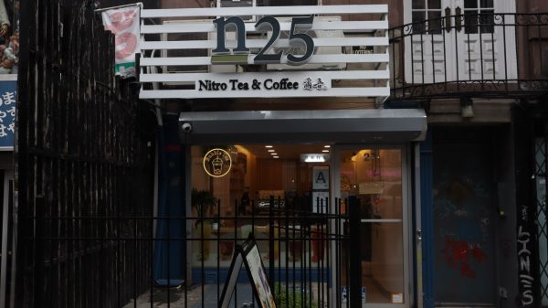 The storefront of a coffee shop that has a modern design with a white sign above that says “n.2.5 Nitro tea and coffee".