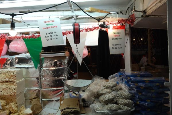 A scale hangs over a table covered in bags filled with chickpeas and nougat candy blocks.