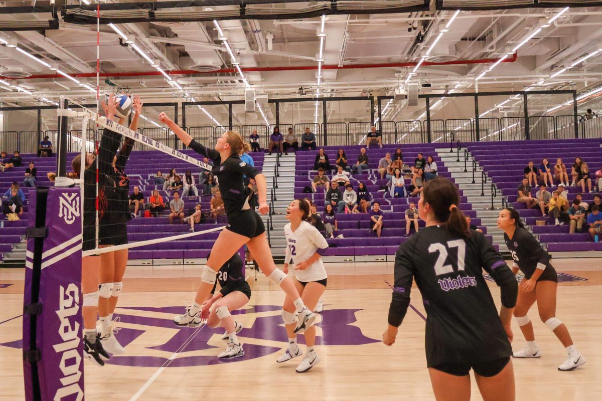 A girl jumps up, swings and hits a volleyball.