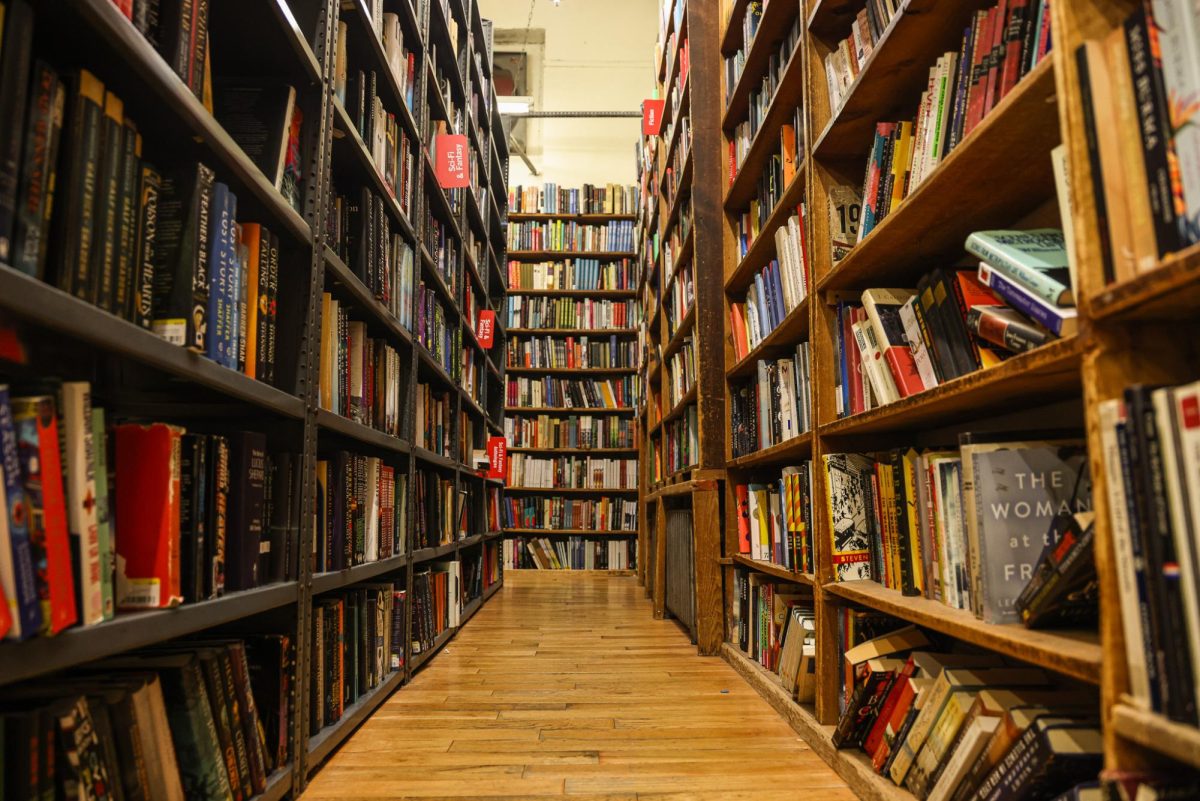 An aisle of bookshelves filled with multicolored books.