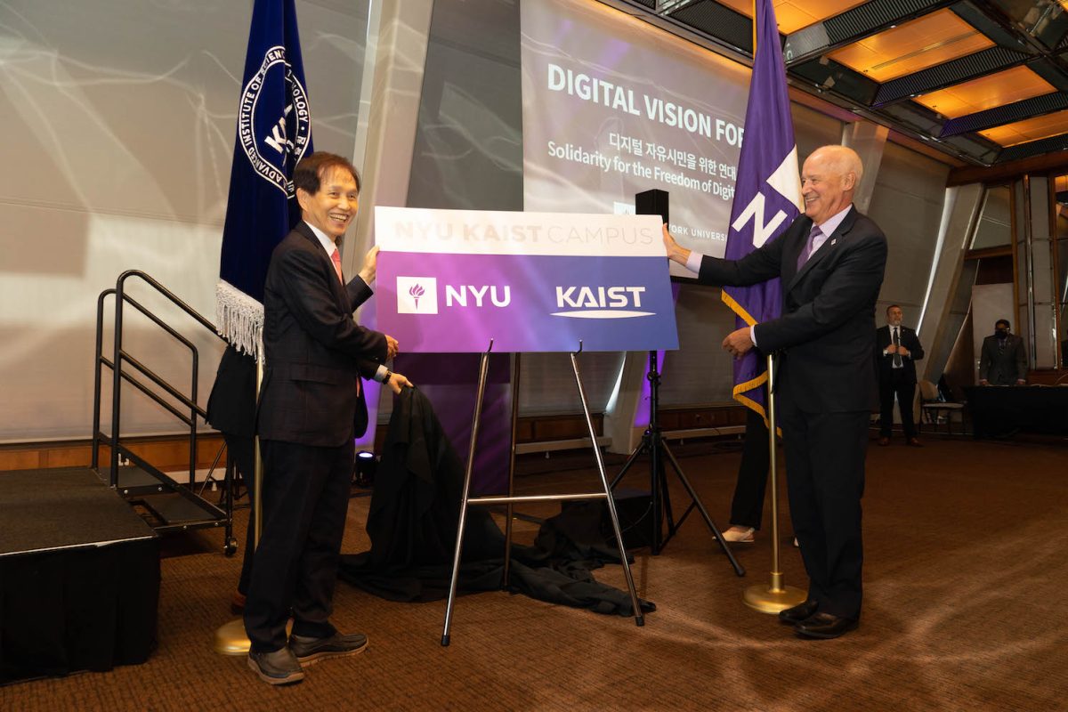 Two men wearing suits happily unveiling a board that reads “N.Y.U KAIST CAMPUS".