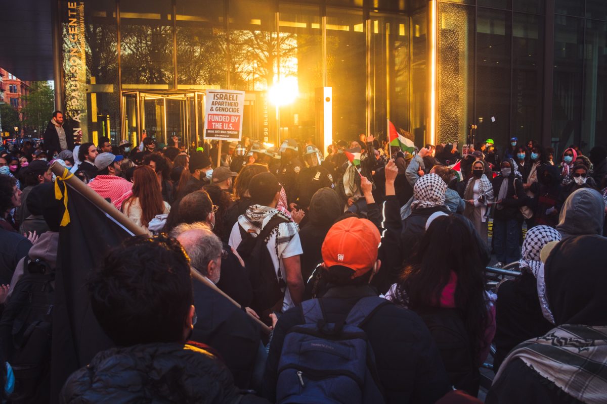 A group of pro-Palestinian protesters demonstrate outside the Paulson Center. A sign held above the crowd reads “Israeli Apartheid and Genocide funded by the U.S.”