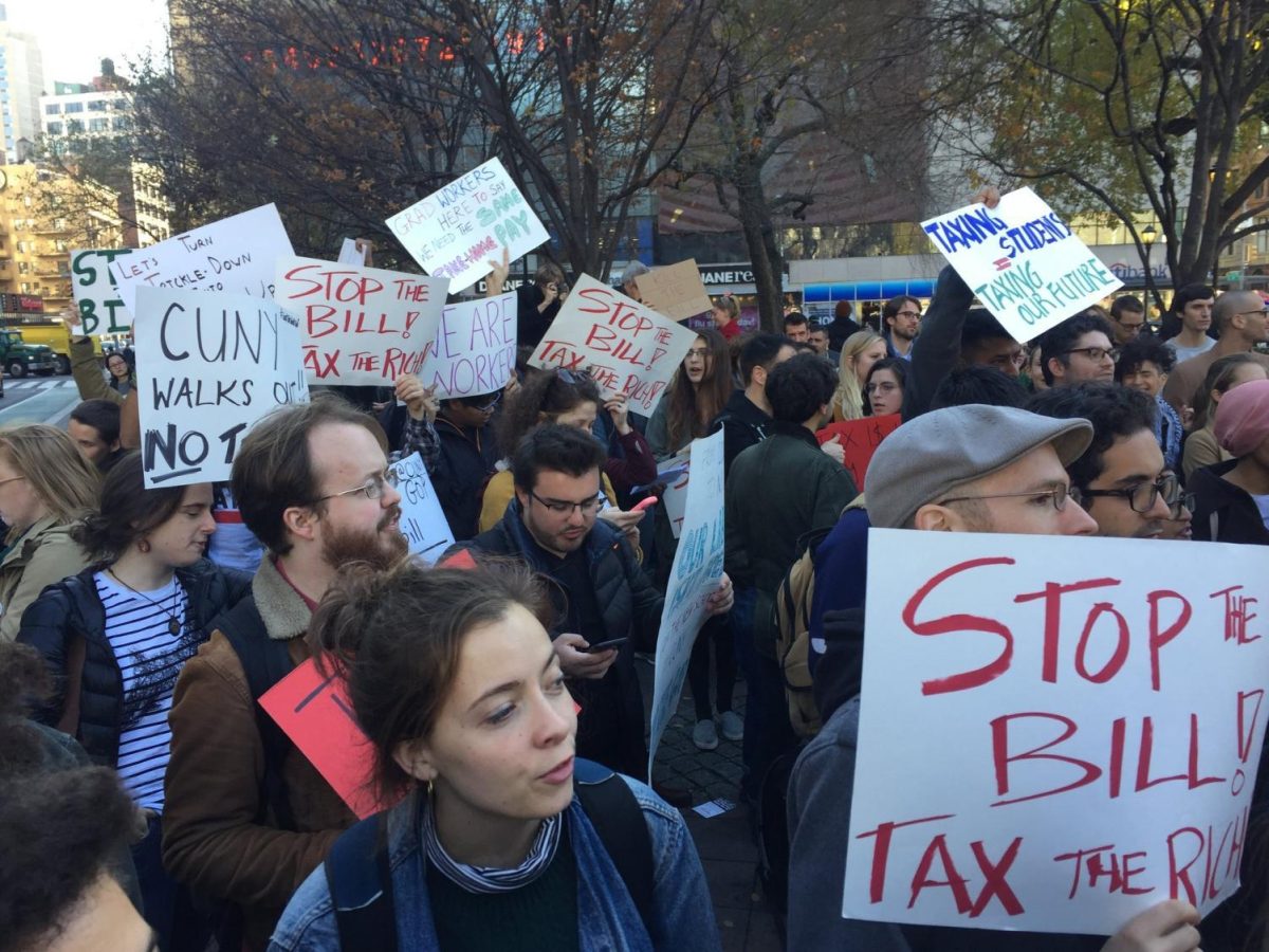 A group of protestors holding various signs outside, many of them reading “STOP THE BILL! TAX THE RICH.”