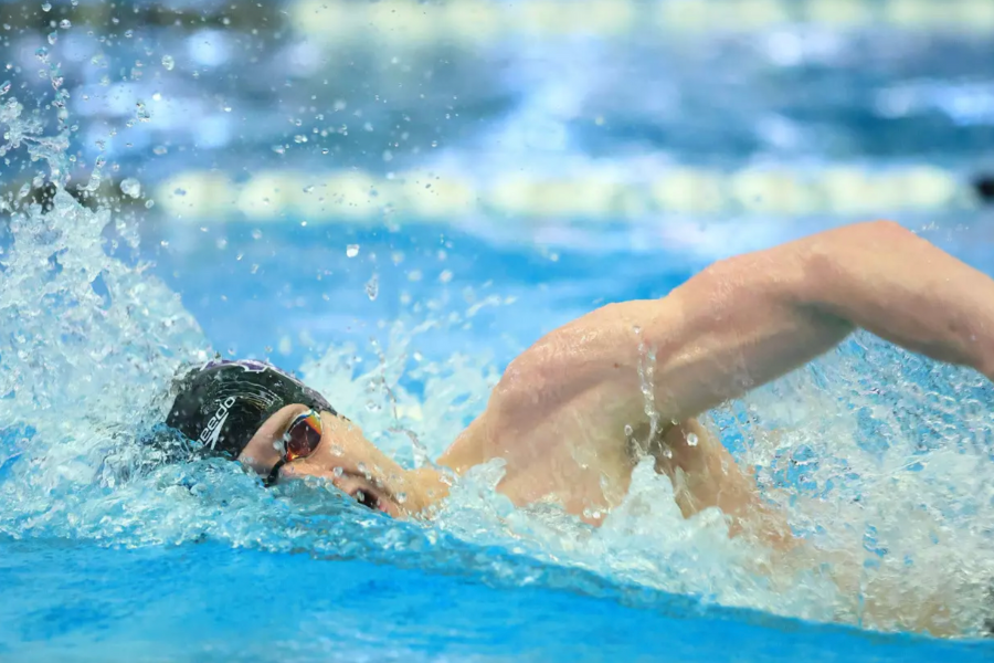 A professional swimmer doing a freestyle stroke in a swimming pool.