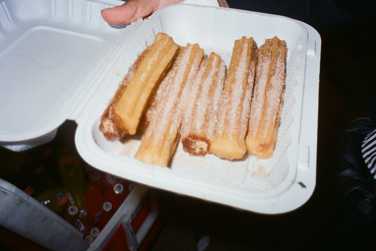 A white to-go box with five churros.