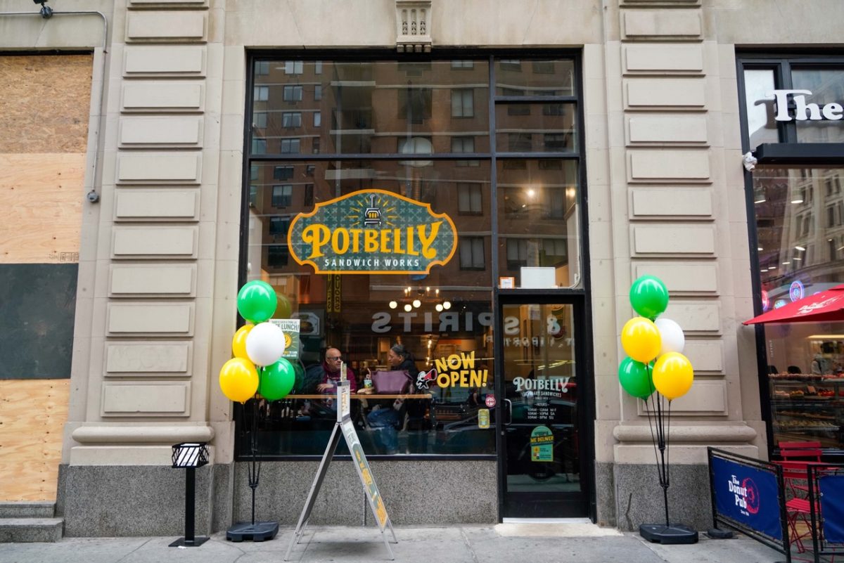 The exterior of a restaurant called “POTBELLY”, which is written in yellow and green with the words “SANDWICH WORKS” below.