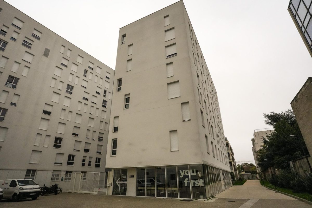 A residential area with white, structural buildings filled with square windows.