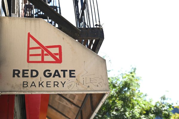 A white awning that says “RED GATE BAKERY" with a red logo. 