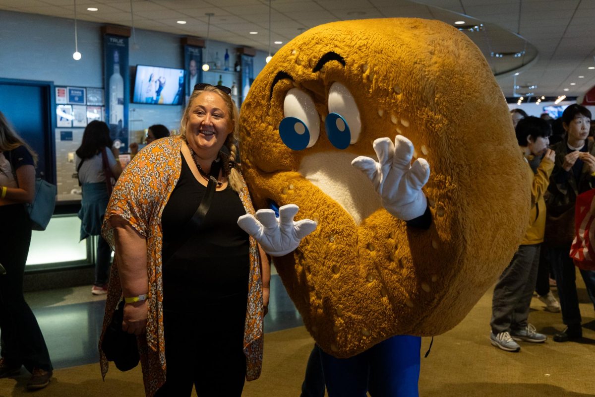 A woman and a person in a bagel costume posing for a photo