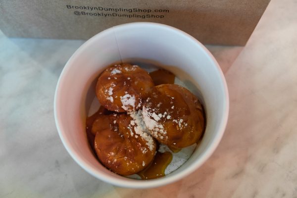 Dumplings with powdered sugar in a white cup.