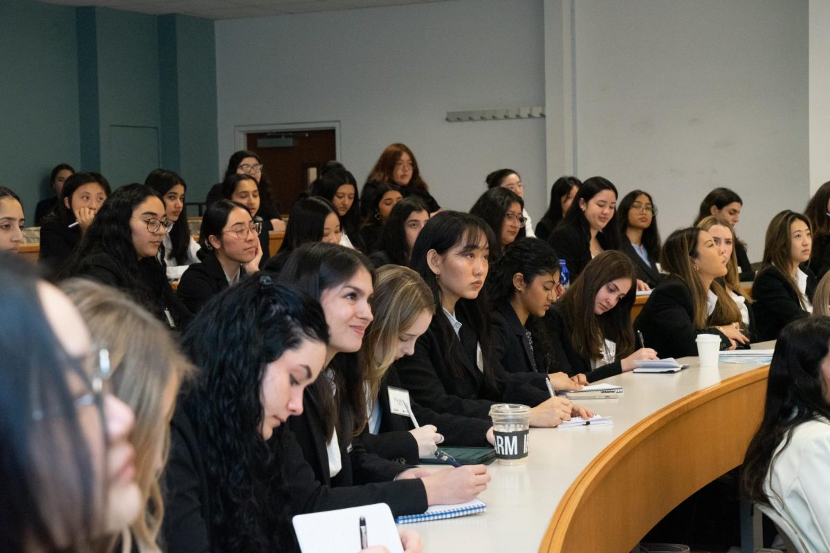 Women sitting in a lecture hall looking forward.