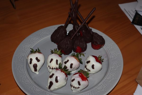 Chocolate-covered strawberries decorated to look like ghosts and broomsticks.