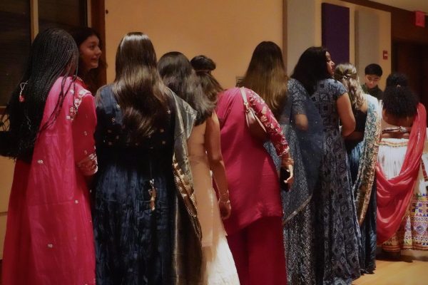 Nine women stand in a line.