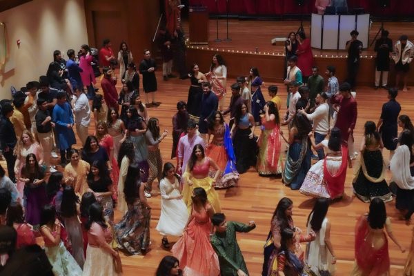 A bird's eye view of many people dressed up and dancing in a hall.