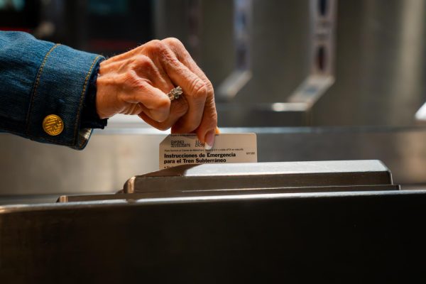 A woman’s hand swipes a metrocard.