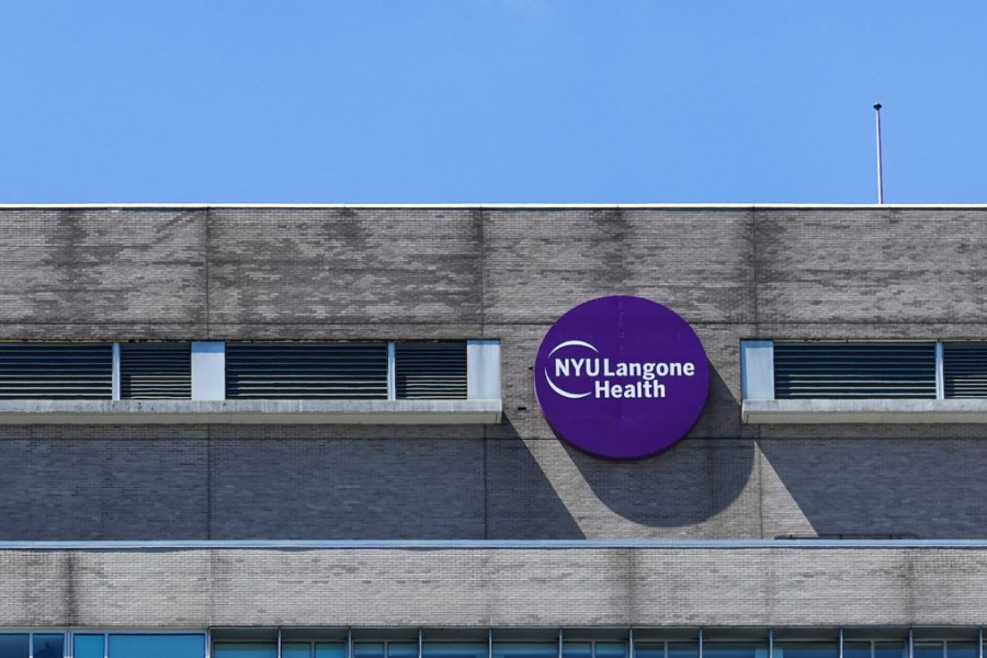 On a building, a round purple sign says “N.Y.U. Langone Health.”