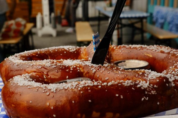 A close-up shot of a salted pretzel with a knife in it.