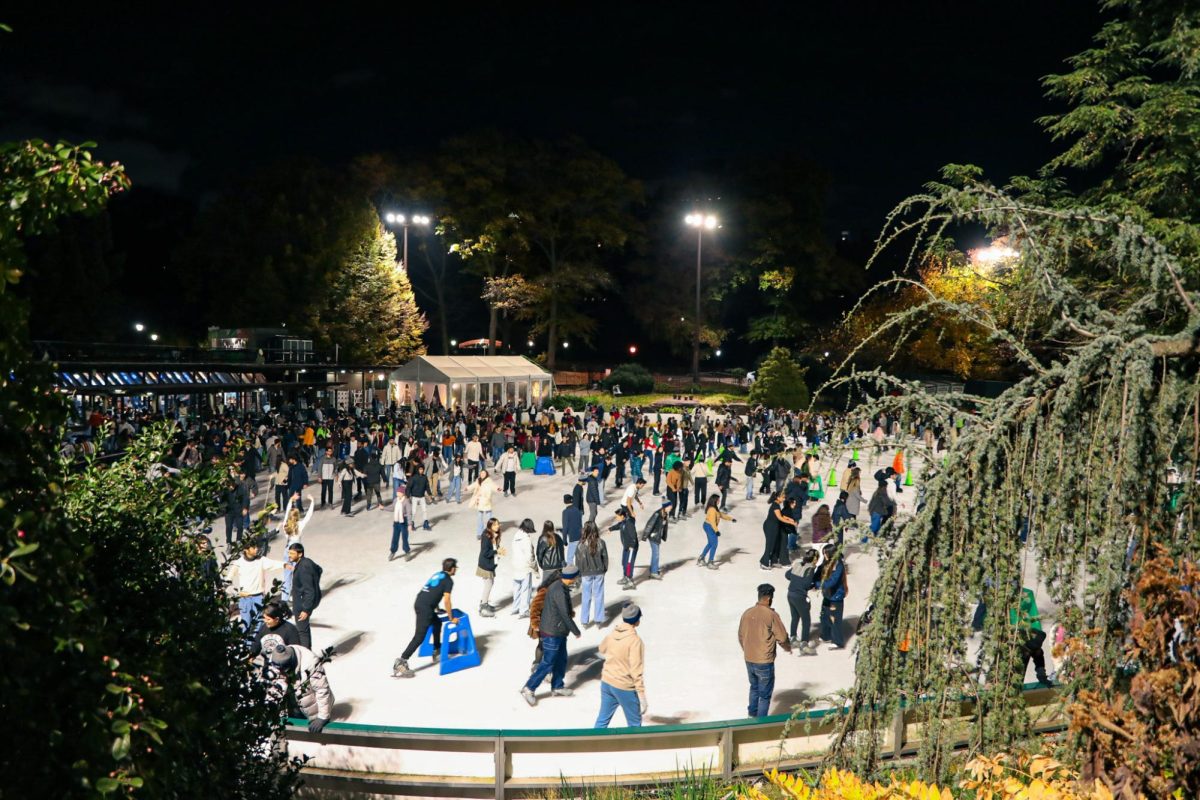 An ice skating rink at night, filled with people.