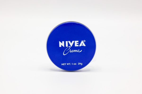 The blue top of a cylinder tub of hand cream. Written on it are the words “Nivea Creme” in white.