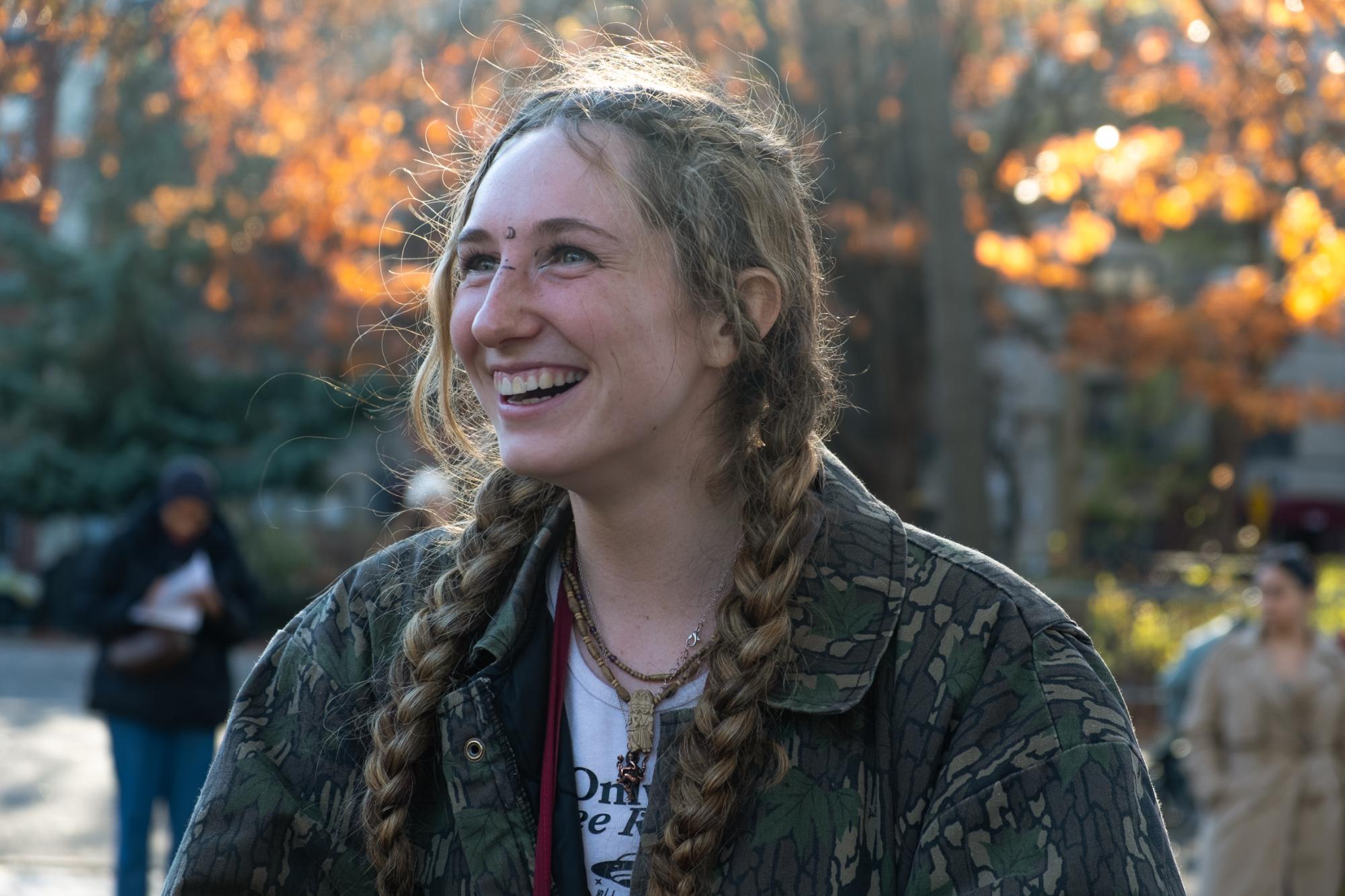 A woman smiling in a park.