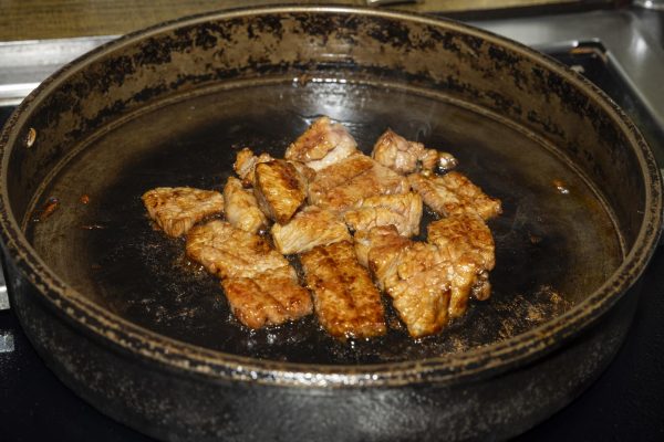 A pan with golden meat cutlets cooking on it.