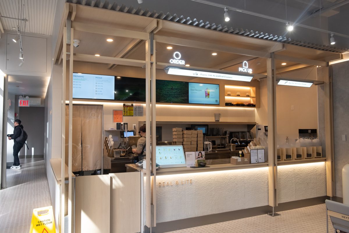 The brightly-lit interior of a store, with an order counter and electronic menu signs.