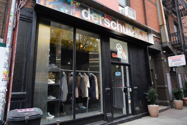 A black storefront with a colorful sign above that reads “dershutze.”