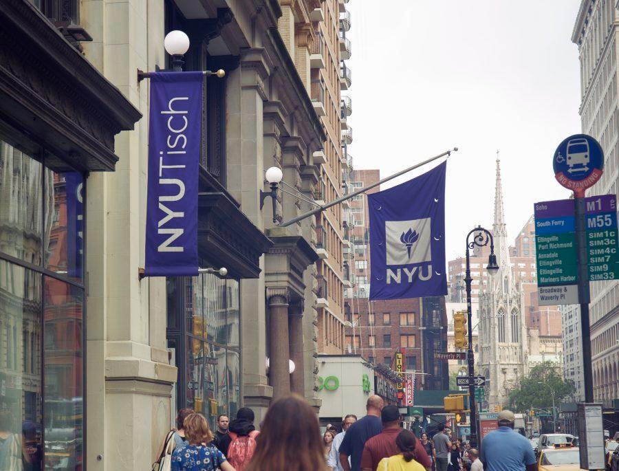 A building facade where an N.Y.U. flag and a banner with “N.Y.U. Tisch” hang.