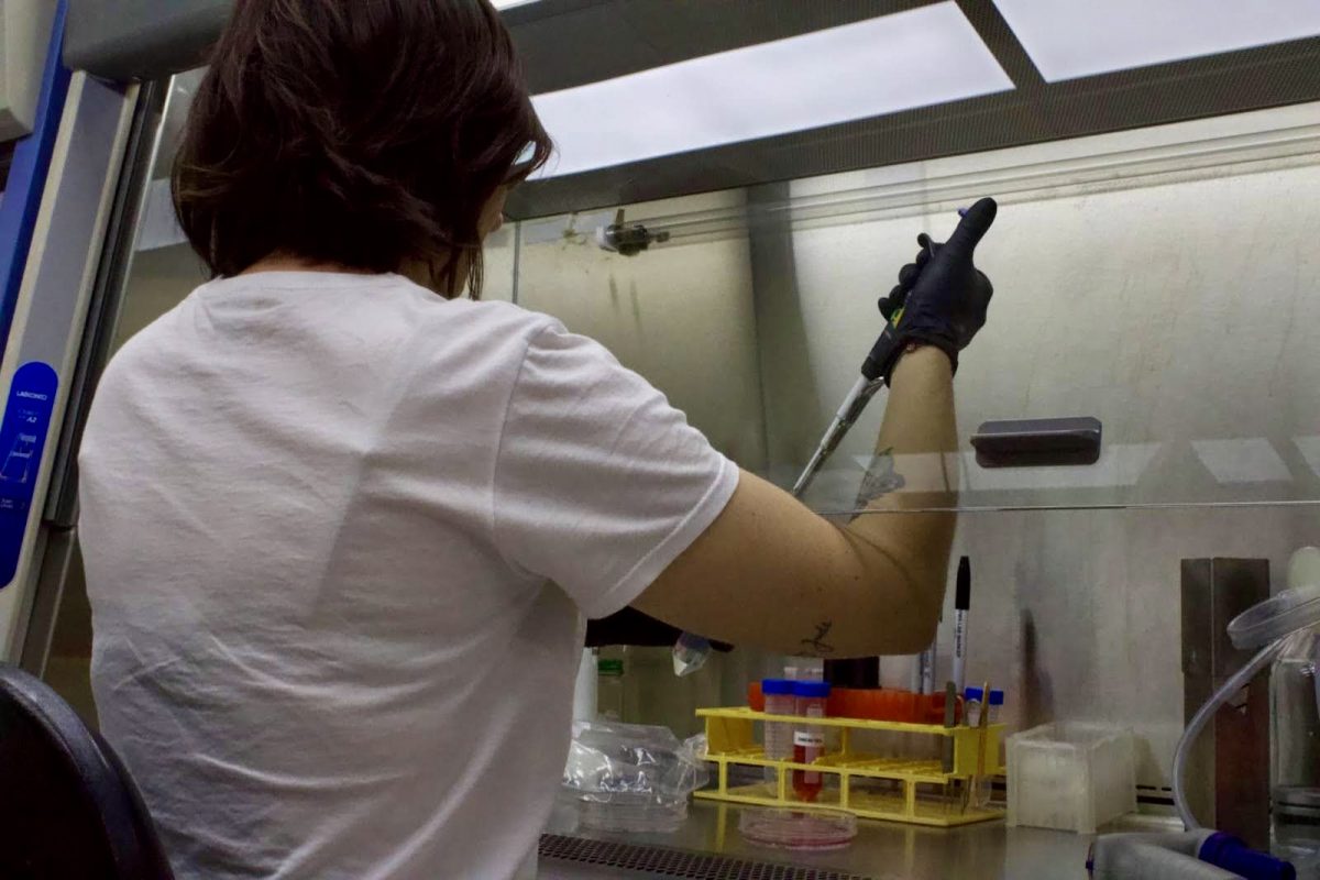 A person using scientific tools in a lab.