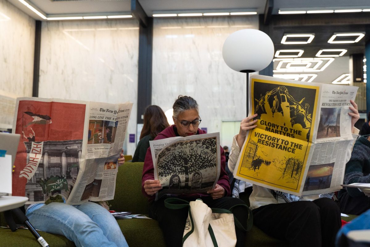 Three people sitting and reading newspapers. One paper reads “GLORY TO THE MARTYRS, VICTORY TO THE RESISTANCE.”