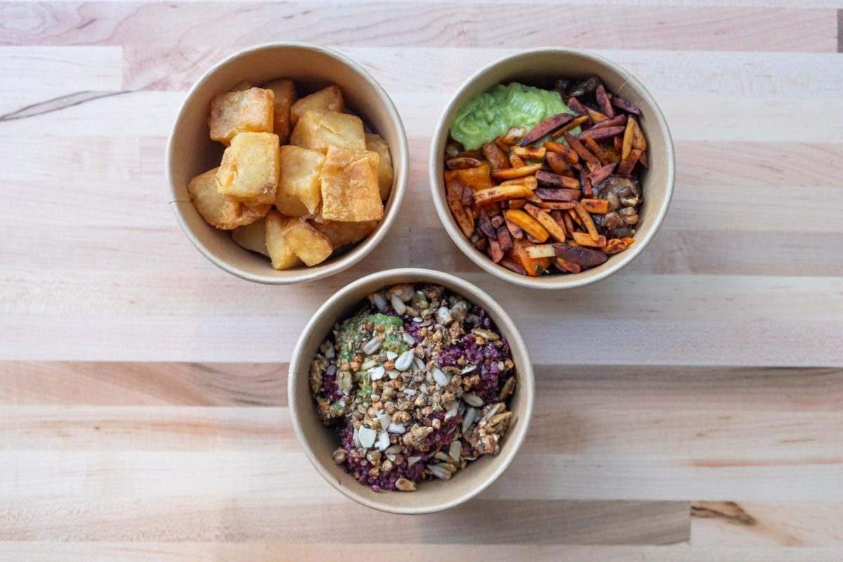 Three side dishes in small round containers sitting in an inverted pyramid form.