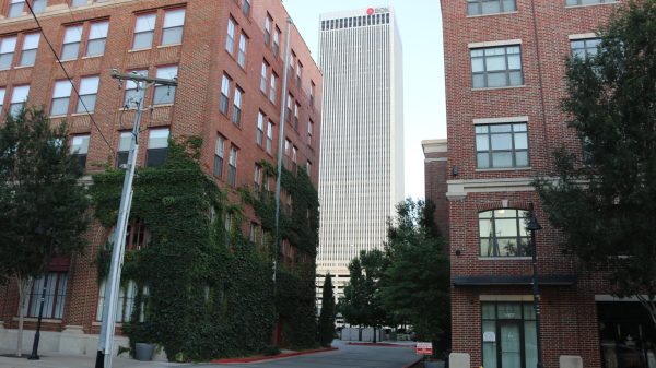 A photo of a brick building with vines growing on the side of the brick.