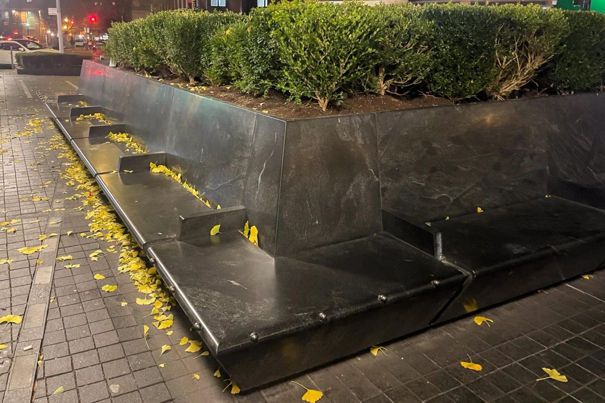 A stone bench with armrests on Astor Place.