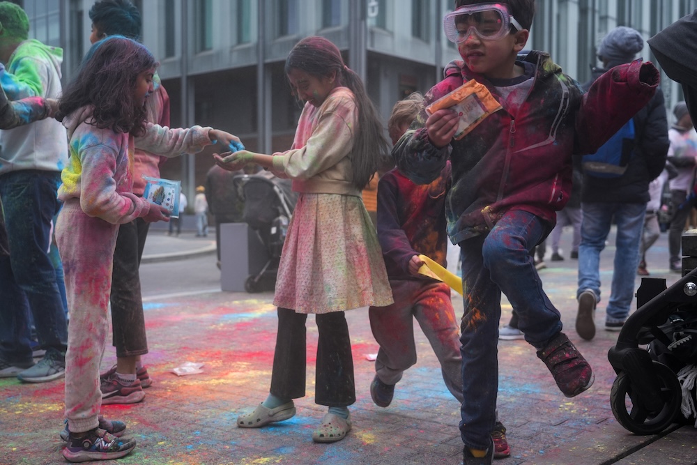 Children exchanging “Gulal,” colorful powder used for Holi. (Anna Prenowitz for WSN)